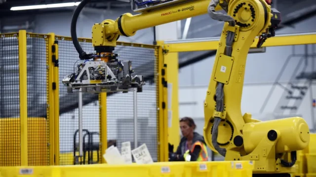 A robot prepares to pick up a tote containing product at the Amazon Robotics fulfillment center in Orlando, Florida
