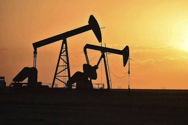 Pump jacks extract oil from beneath the ground in North Dakota, May 19, 2021