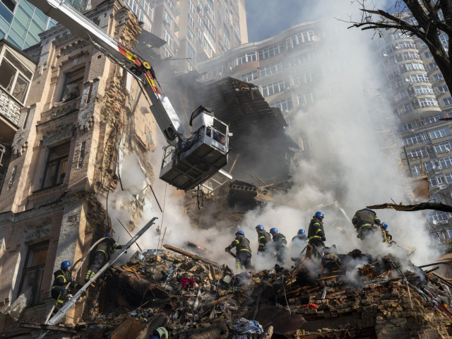 Firefighters dig through the rubble after a deadly drone attack on residential buildings in Kyiv on October 17, 2022.